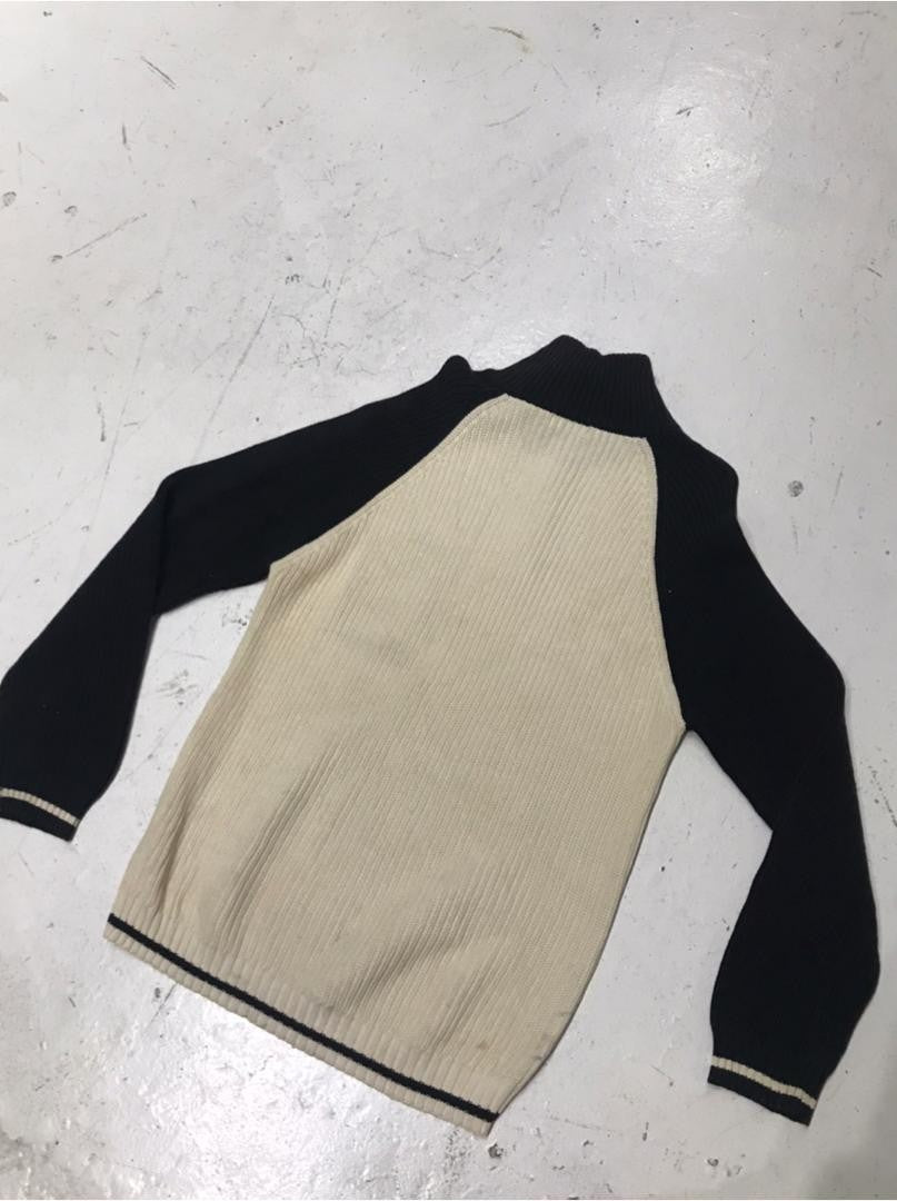 SPIRAL STORE beige and black knit sweater with ribbed texture and contrast trim on cuffs and hem.