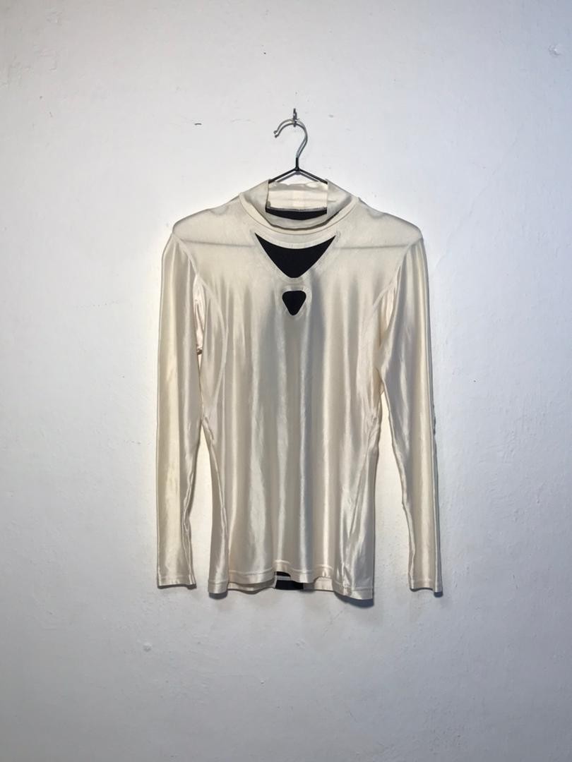 SPIRAL STORE cream long sleeve top with cut-out details at the neckline and chest, mock neck.