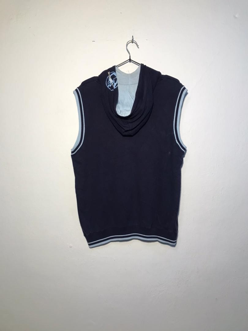 SPIRAL STORE navy blue sleeveless hoodie with drawstring hood, kangaroo pocket, and light blue trim. Cotton blend.